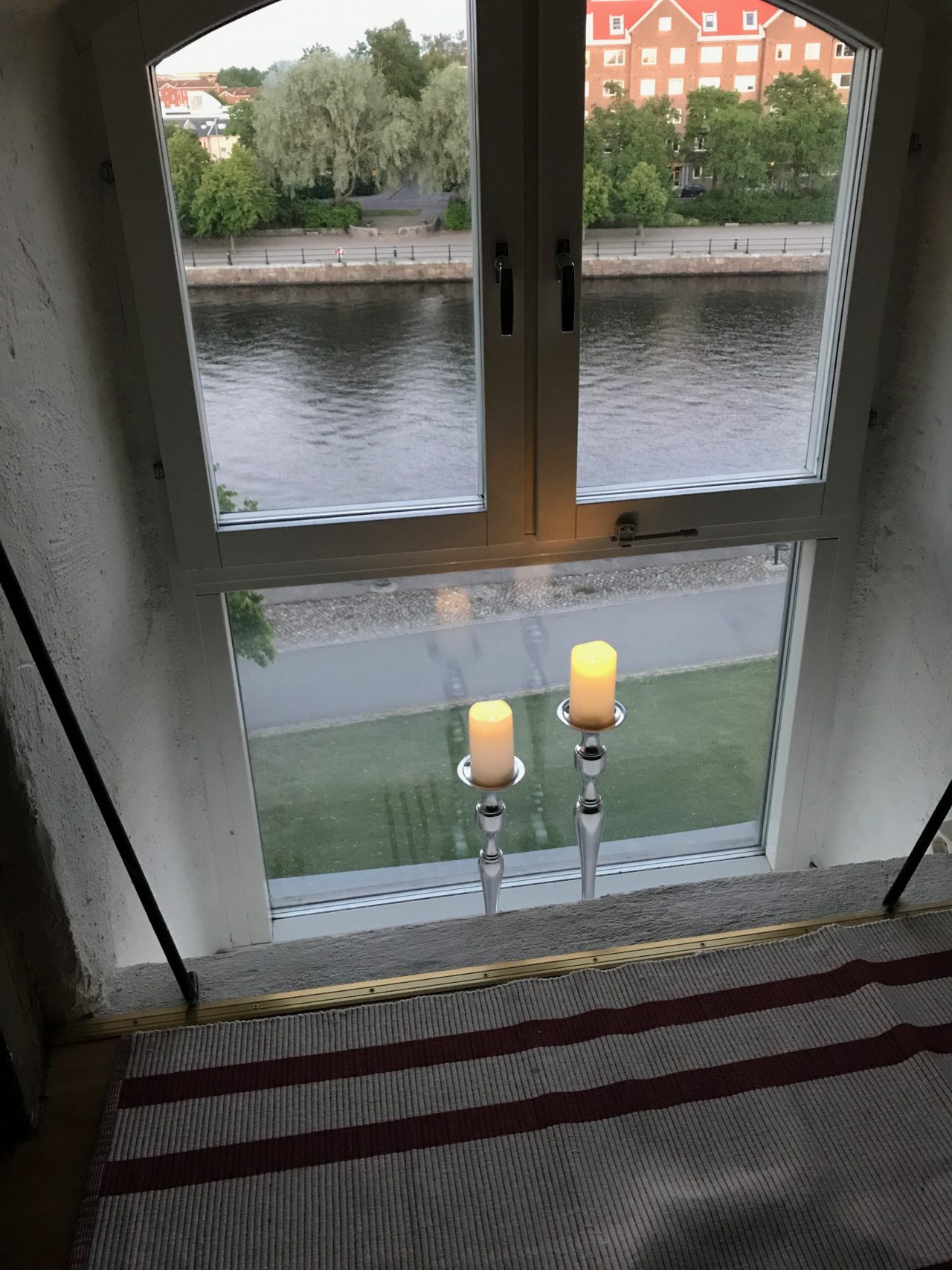 Attic Window With Cozy Lit Candles Overlooking River