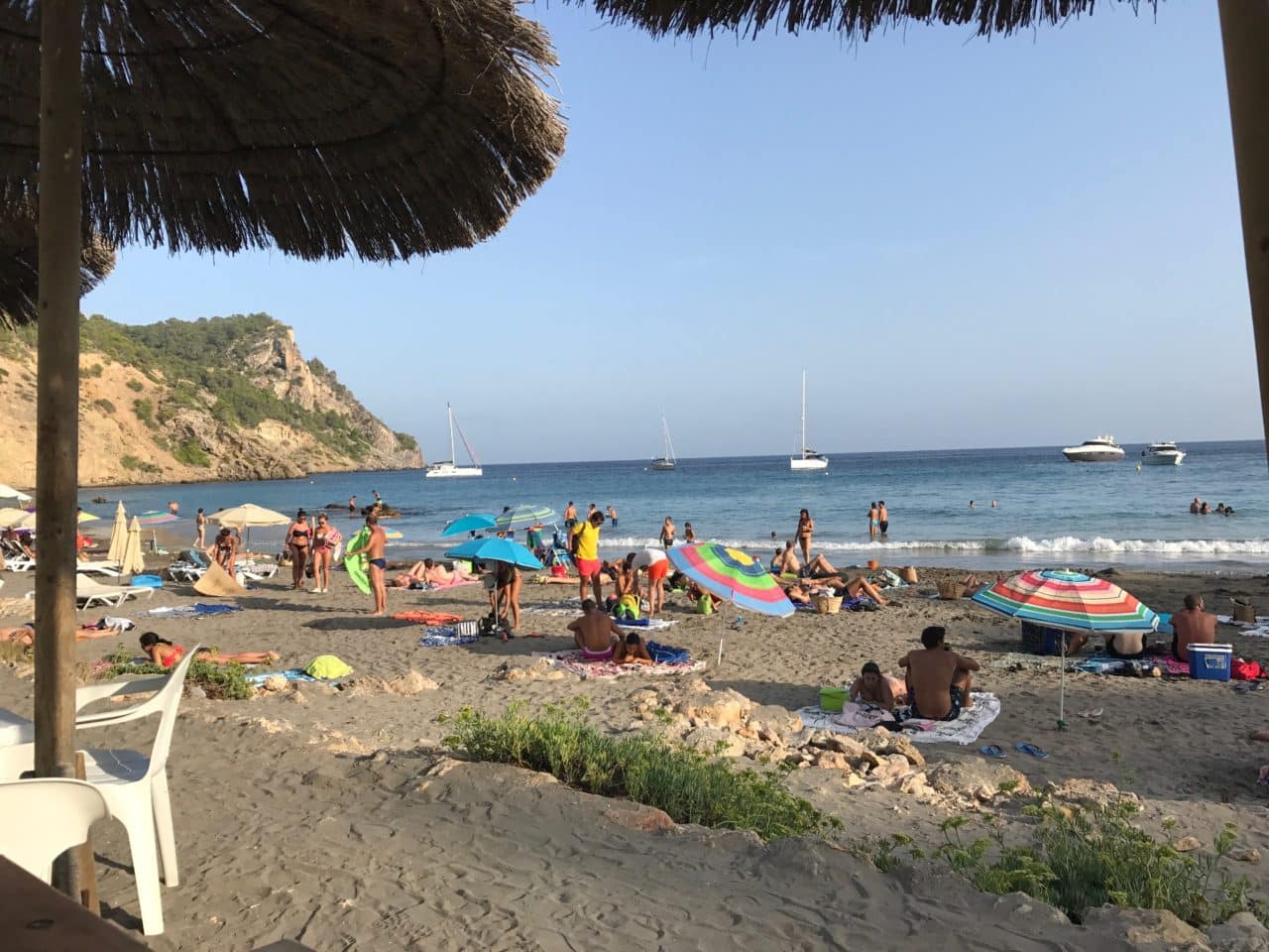 People Sun Bathing On A Beach With Umbrellas