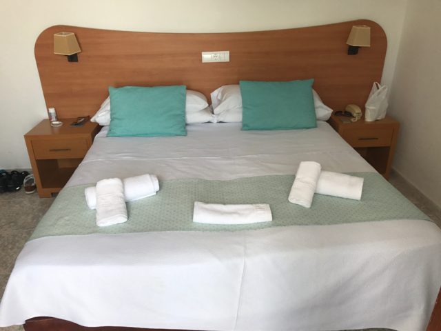 Hotel Bed With Sidetables And Towels And Pillows In Top