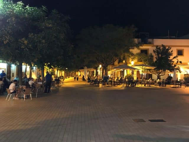 A Square With Cafés, People And Trees At Night