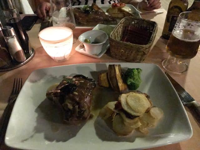 A Plate Of Steak And Potatoes On A Candle Lit Table