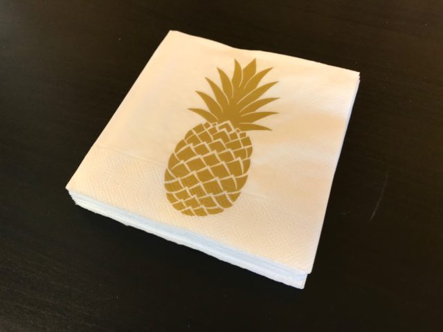 Golden Pineapple Napkin On A Black Table