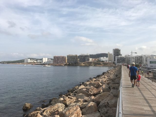 People Walking On A Pier With City View