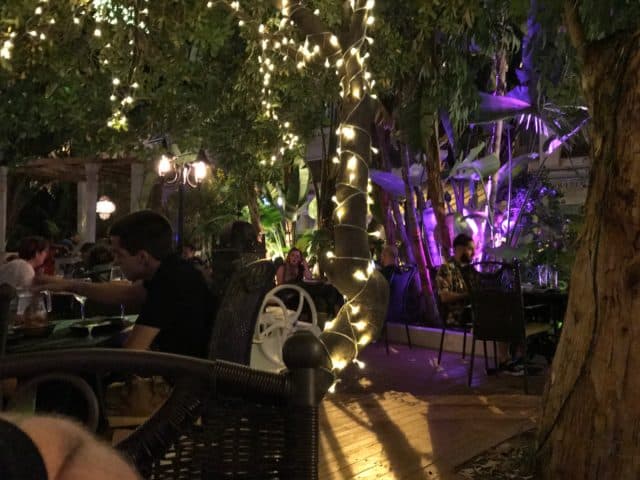 People Aitting Food At Tables Eating In A Restaurant With Lights