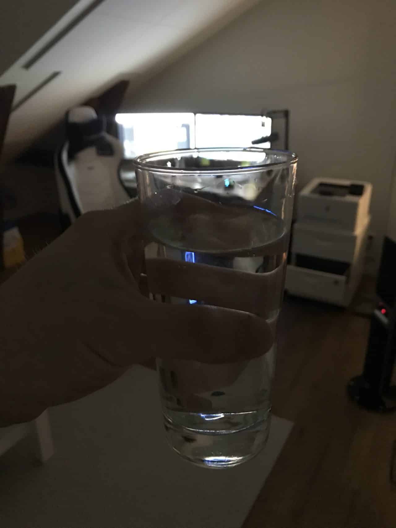 Holding A Glass Of Water In An Office Room