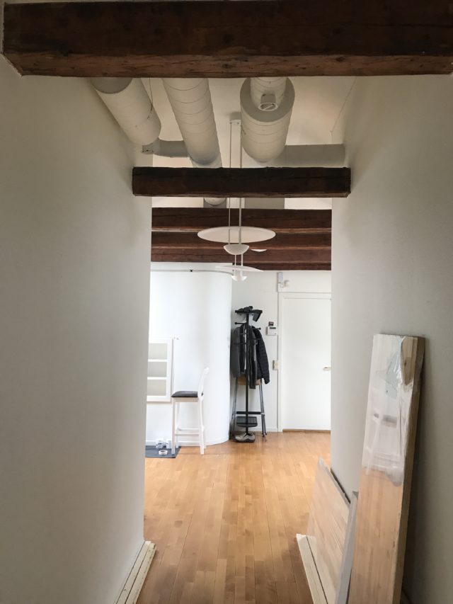Office Hallway With Wooden Beams In Ceiling And A Clothes Hanger