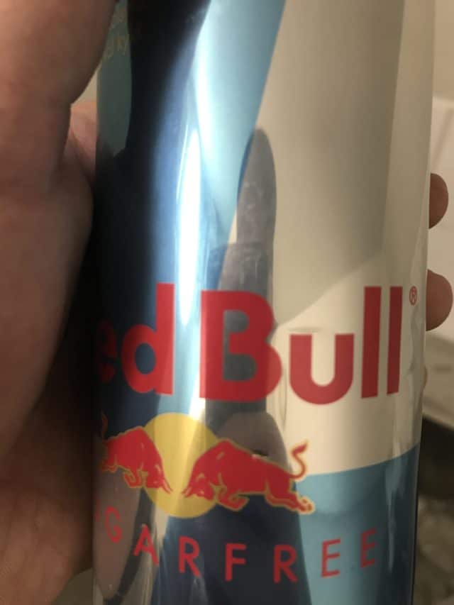 Closeup Of Hand Holding A Red Bull Aluminum Can