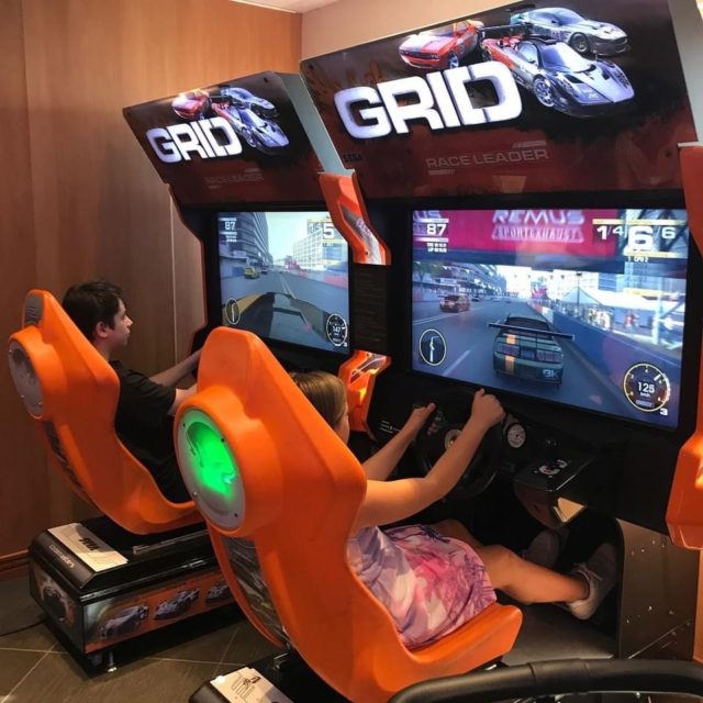 Children Competing In Car Games In Gaming Hall