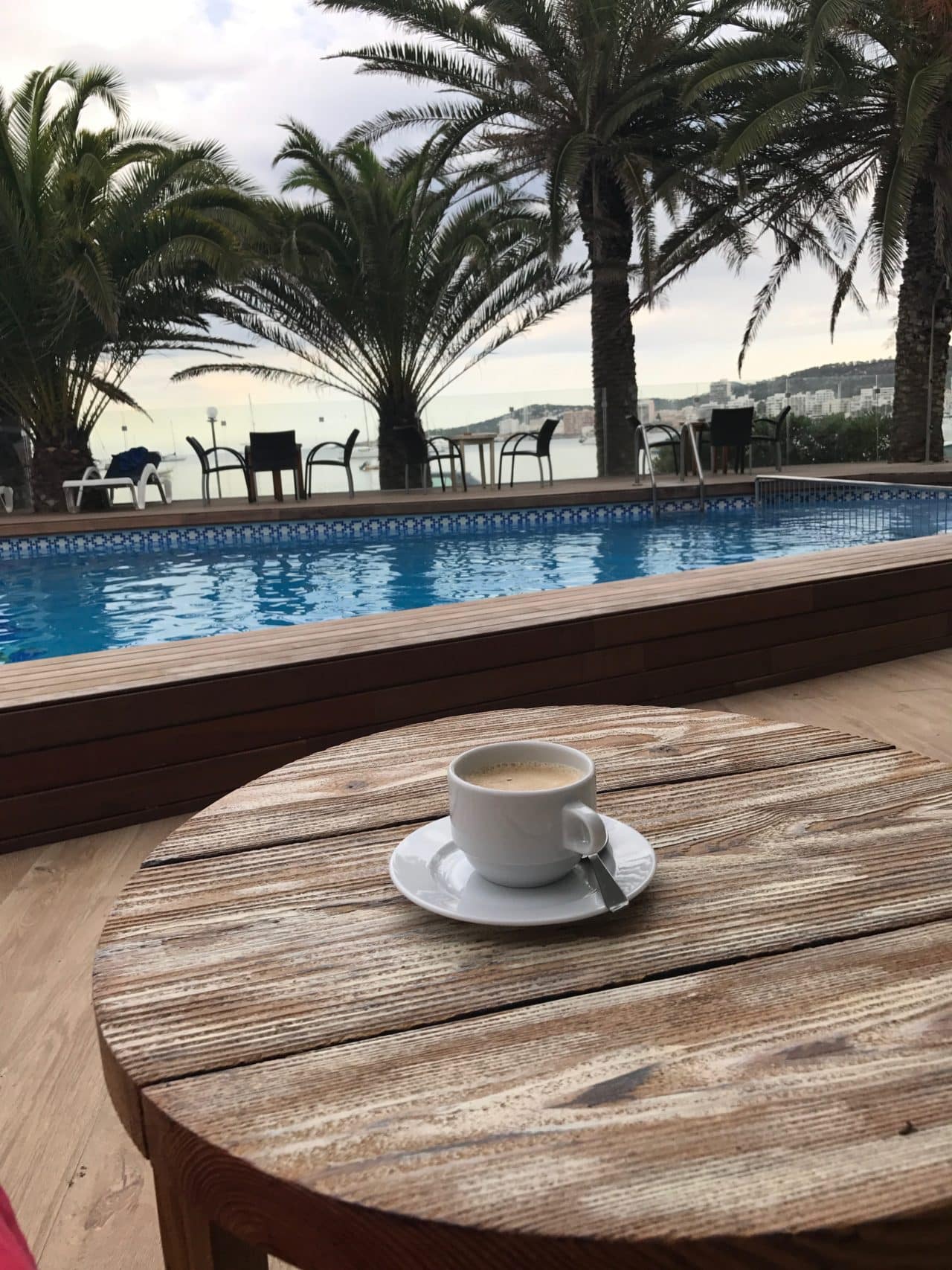 Coffee In A White Coffee Cup On A Wooden Table In A Hotel In Spain Overlooking Pool And Sea
