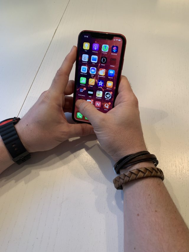 Man With Bracelets Holding A Red iphone With Apps Visible