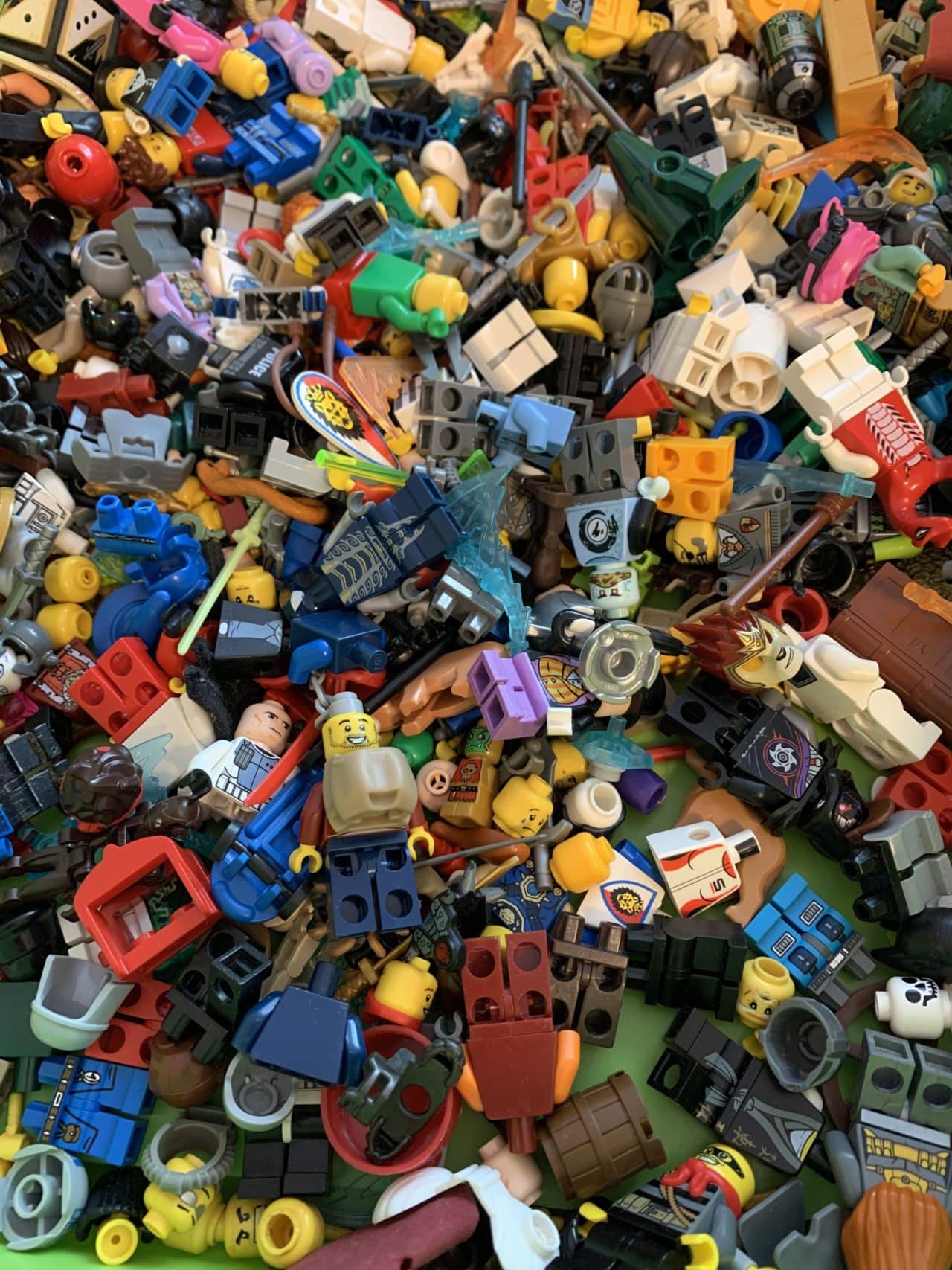 Lego Mini Figurines And Brick Pieces In A Green Collection Box