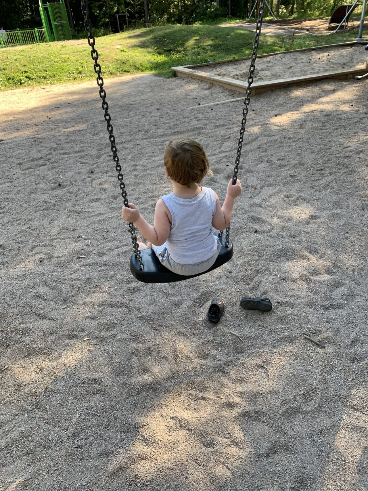 Small Kid Swinging On A Swing In Playground