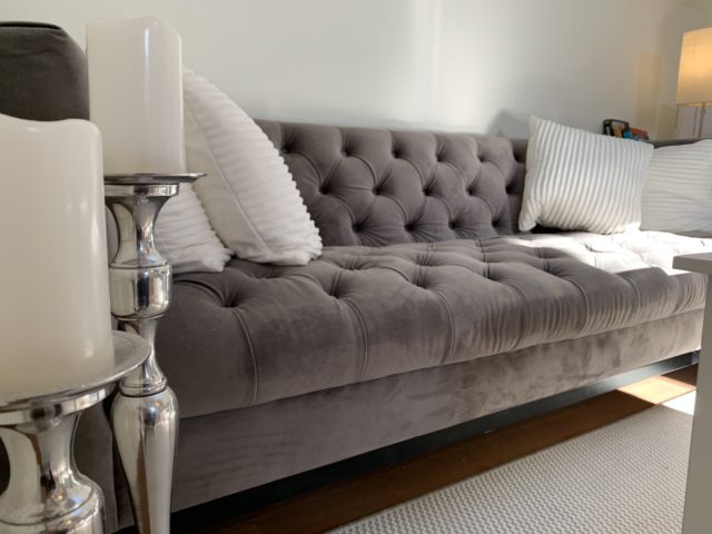 Velvet Couch With White Pillows And Candles