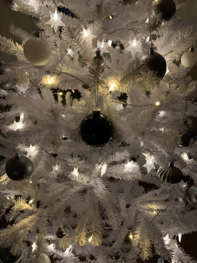 White Christmas Tree With Glitter And Gray Baubles And Star Lights
