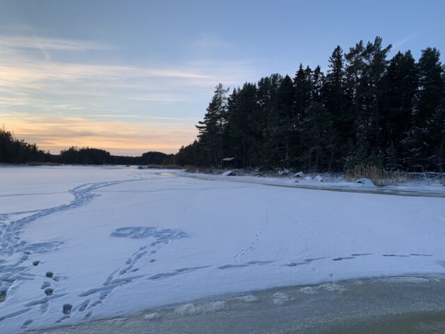 Frozen Lake At Sunset With Footprints In The Snow