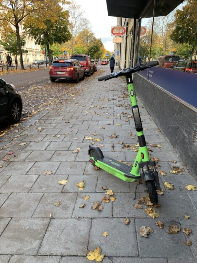 Green Public Usage Electric Scooter On City Street