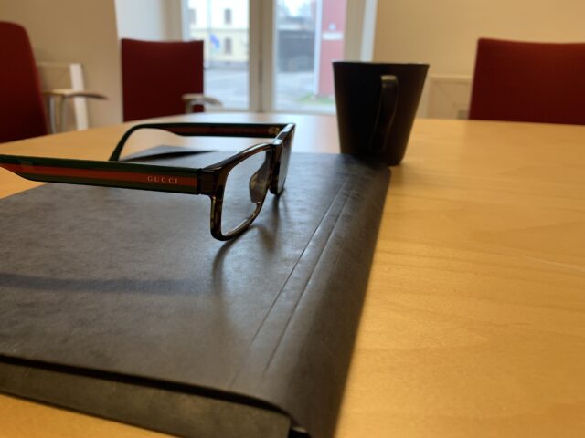 Gucci Glasses On A Document Paper Folder On Conference Table
