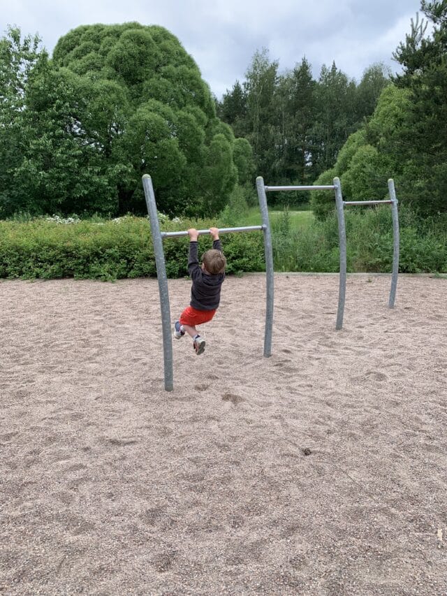 Child Playing On Bars In Playground