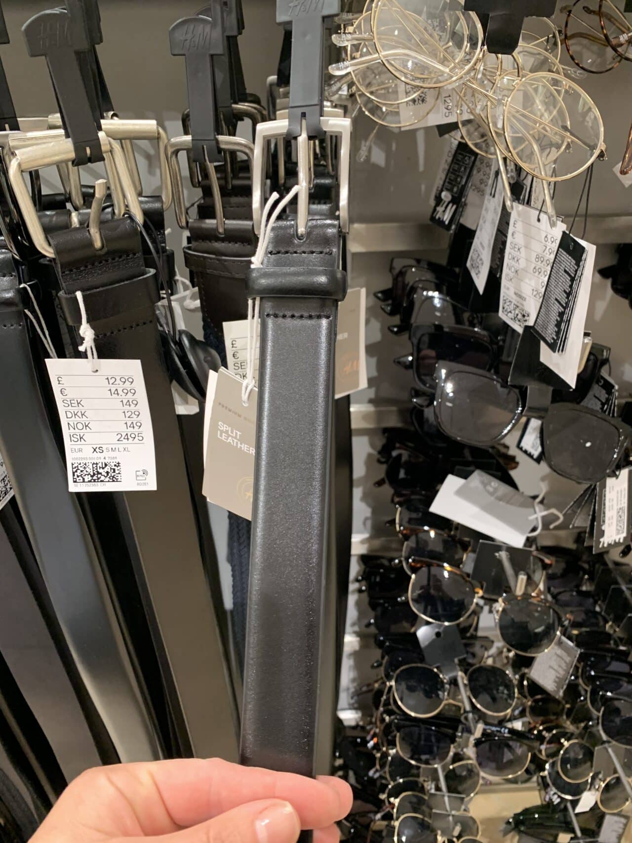 Store Rack With Black Belts And Glasses With Price Tags