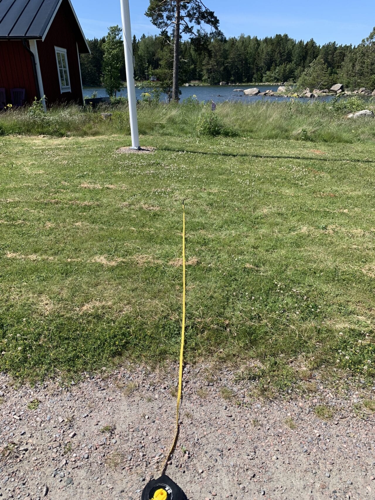 Measuring tape Rolled Out On Lawn With A Flagpole