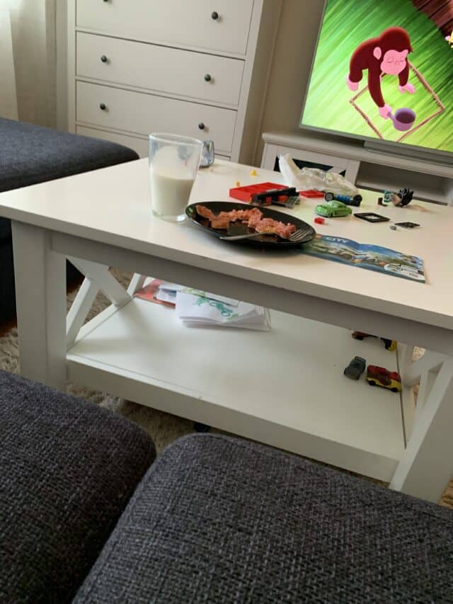 Plate With Pizza And Glass Of Milk In Livingroom By TV With Cartoon