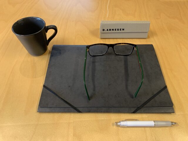 Black Office Binder On A Table With A Cup And Glasses And A Pen