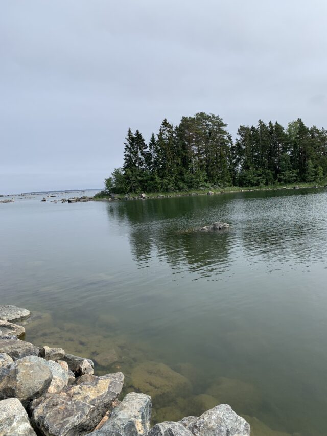 Island In Calm Ocean In Overcast Weather