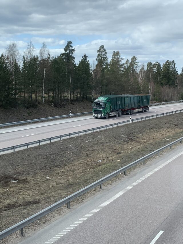 Green Truck And Trailers Driving On The Highway Road
