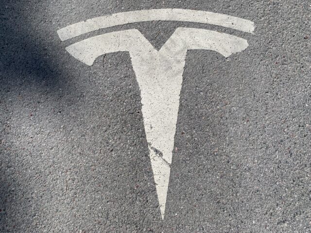 Tesla Logo On Asphalt At Supercharger Station