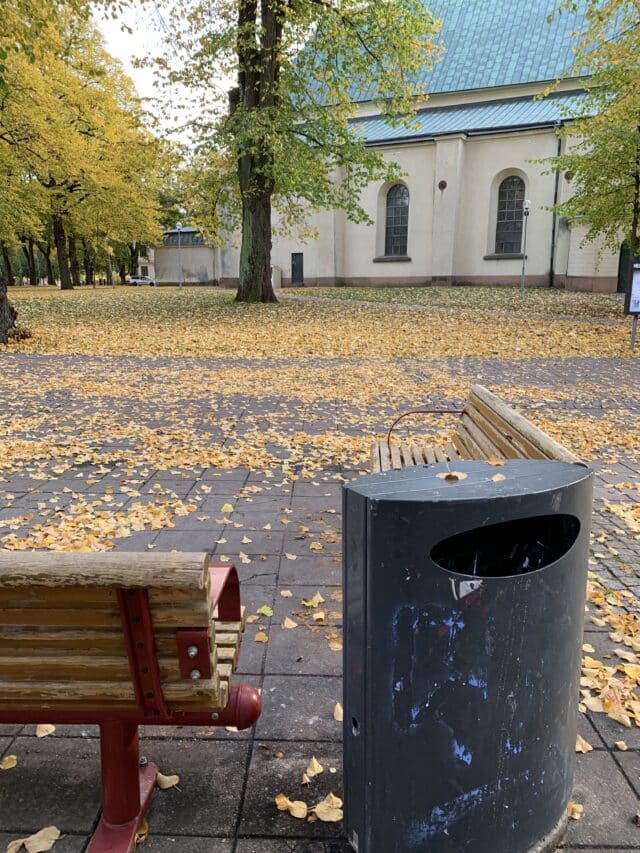 White Church With Park Bench And Trash Can