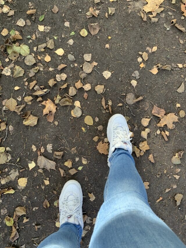 Woman Walking Outdoors Wearing Fila Shoes And Jeans