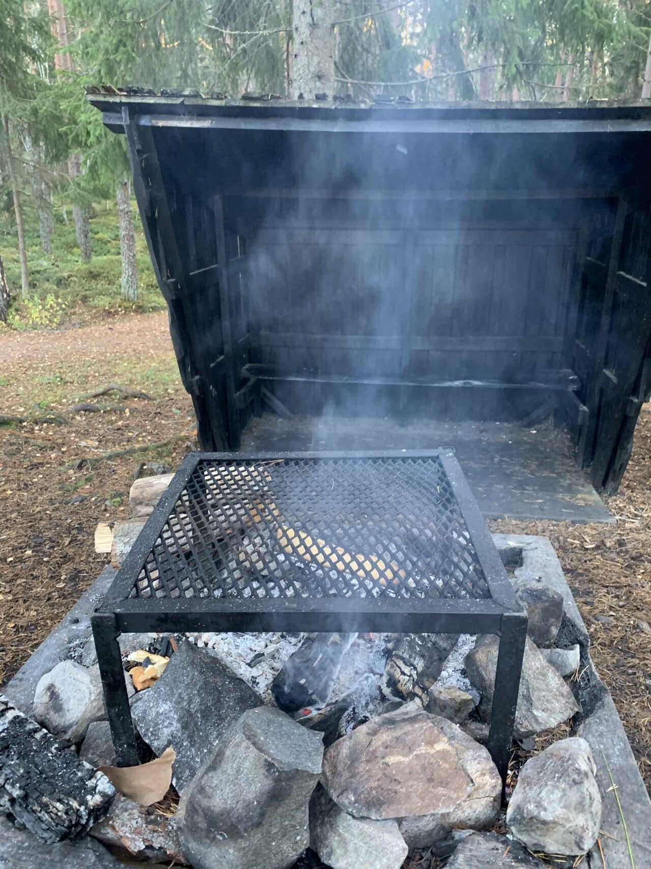 Smoking Firepit With Barbecue Grate At Wilderness Camp Site