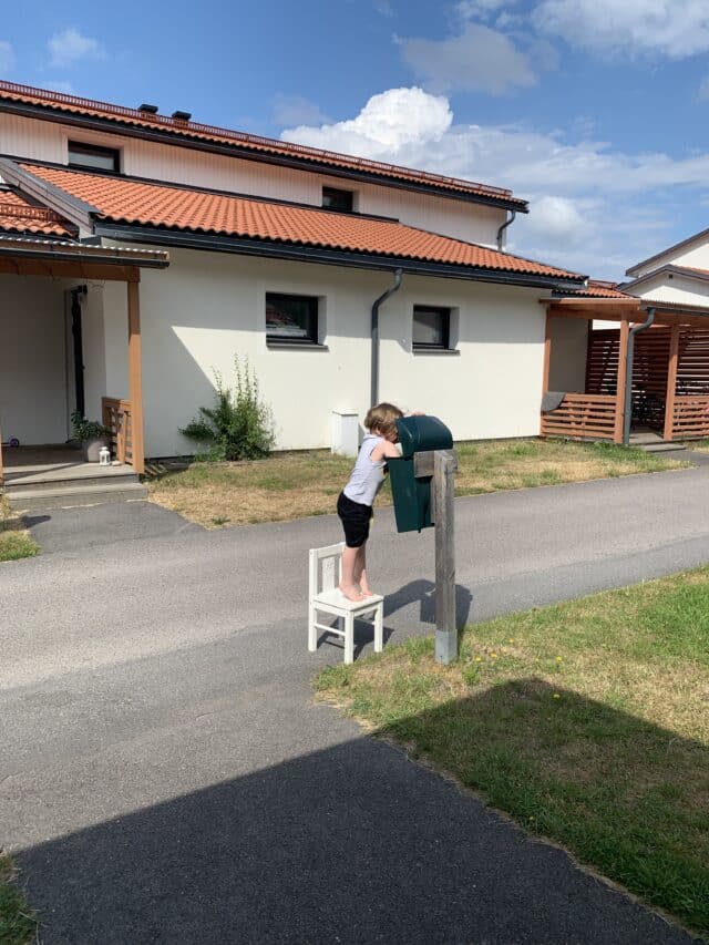 Small Child Getting Mail In Mail Box Using A Chair